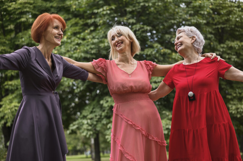 Older women joyfully dancing together, celebrating vitality and wellness in the menopause phase.
